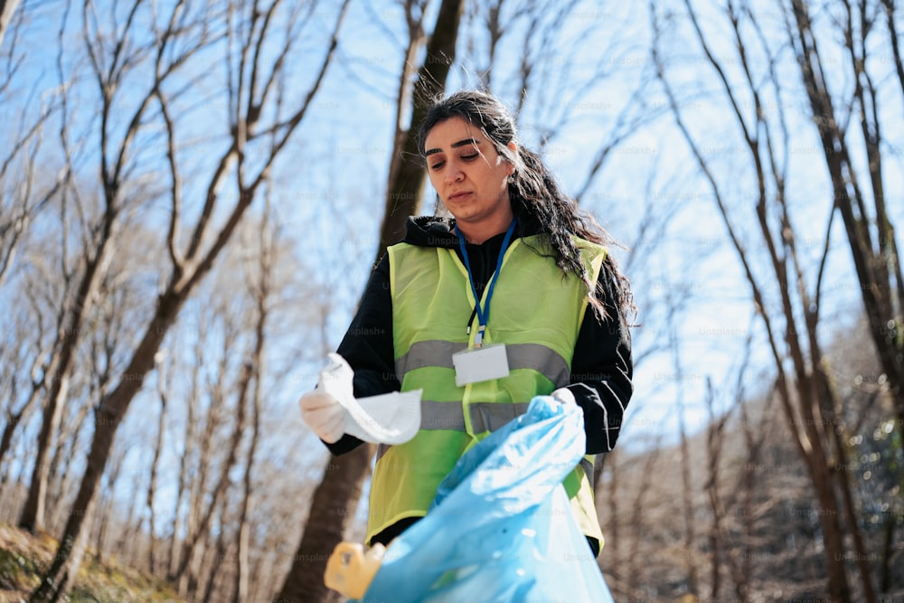 a woman in a green vest holding a blue bag