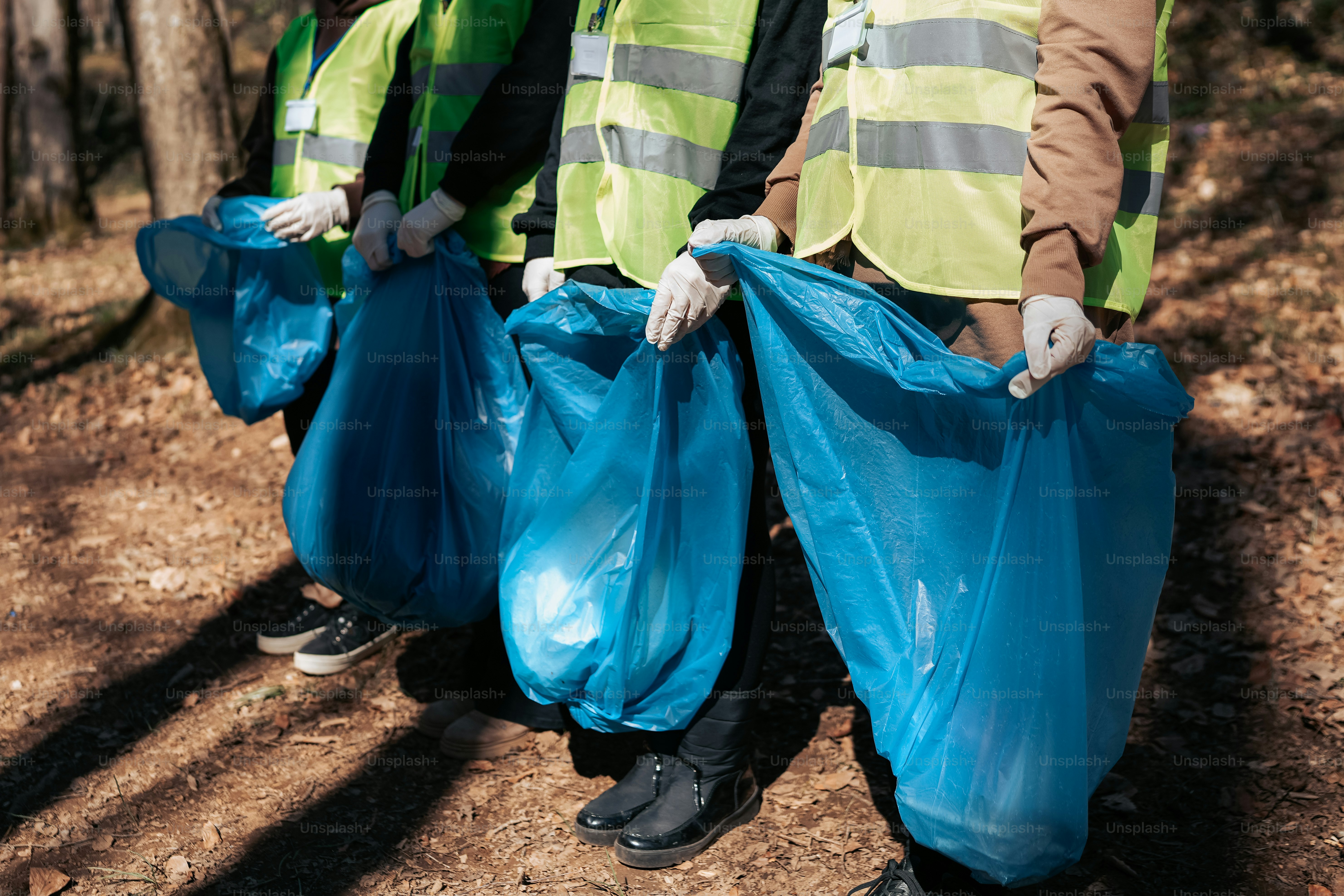 a group of people standing next to each other holding blue bags