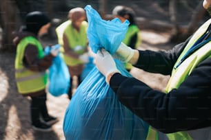 a group of people wearing safety vests and holding a blue bag