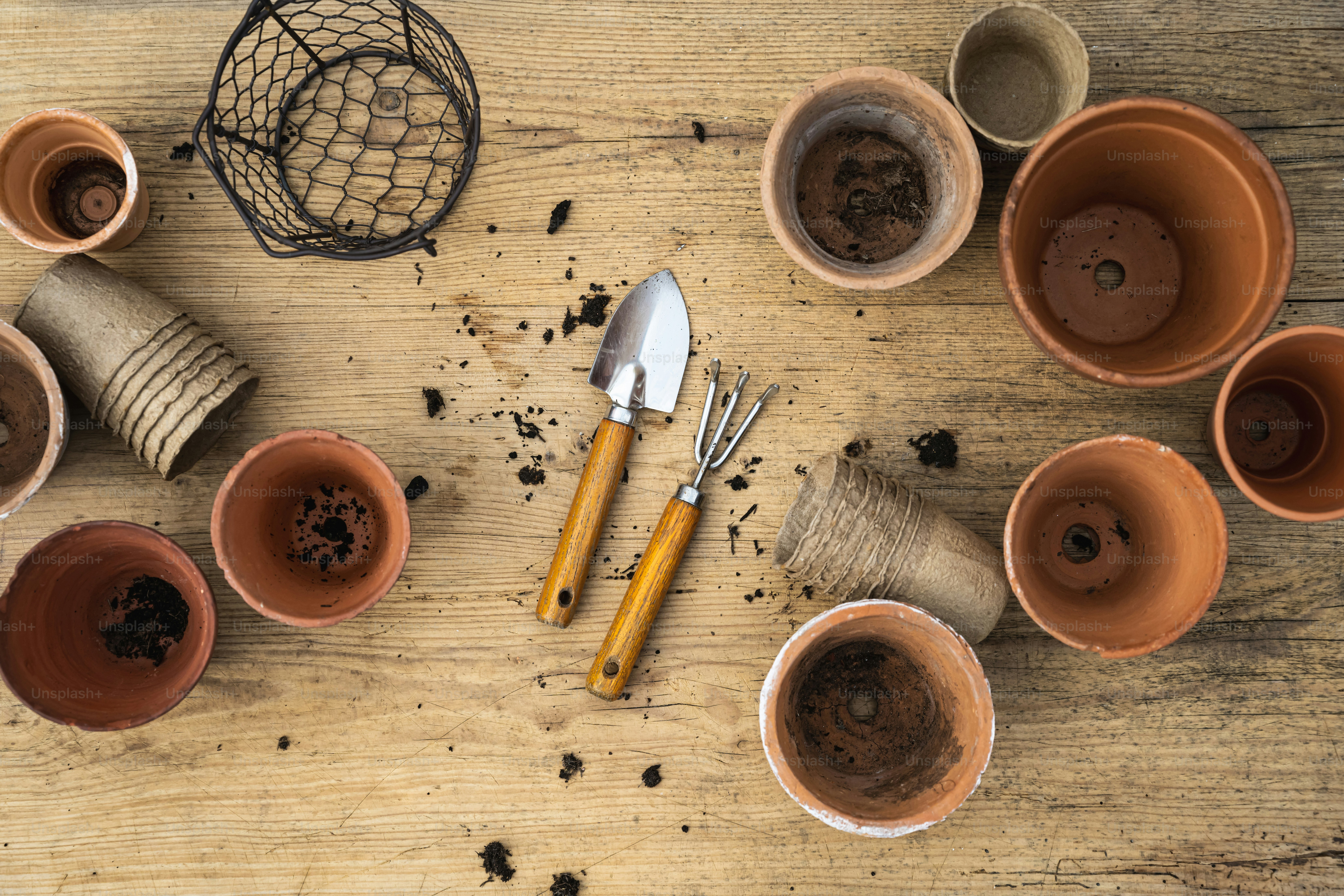 a wooden table topped with lots of clay cups and utensils