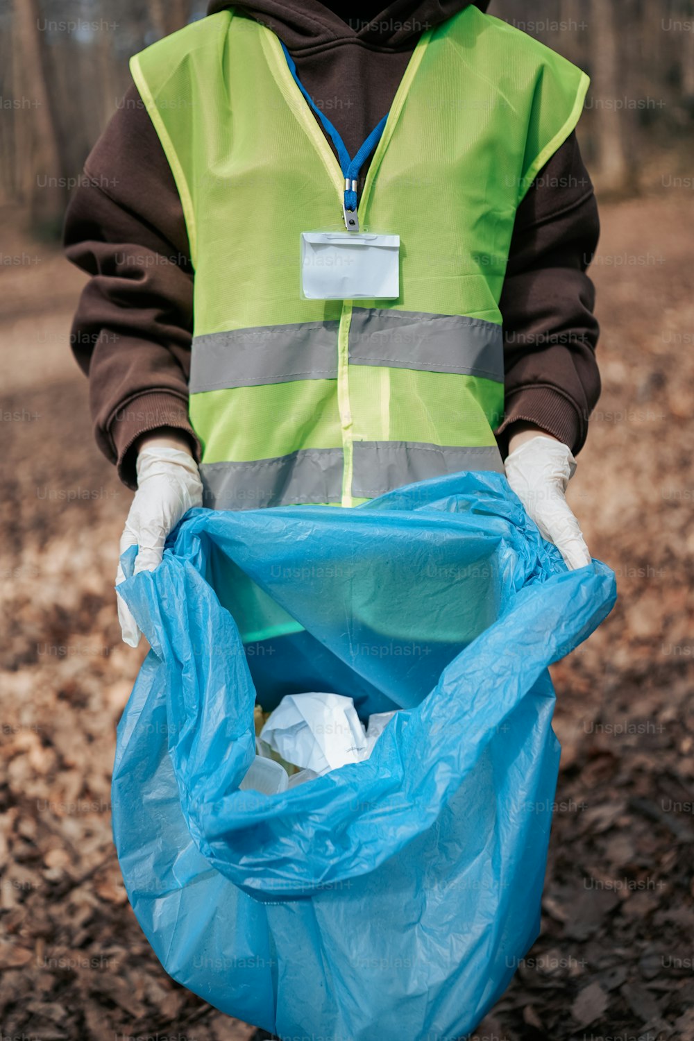 a person in a safety vest holding a blue bag