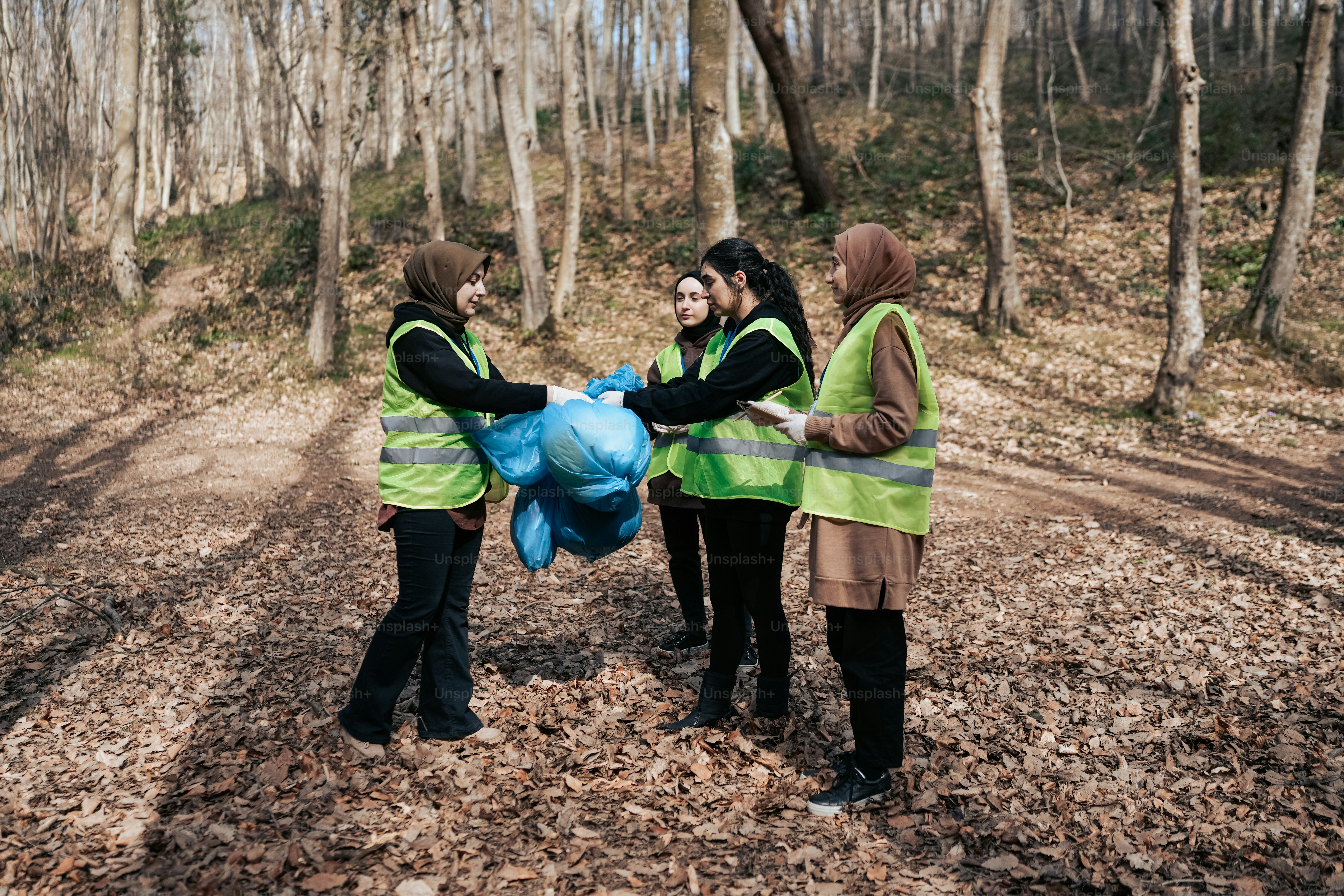 a group of people standing in a forest holding a blue balloon