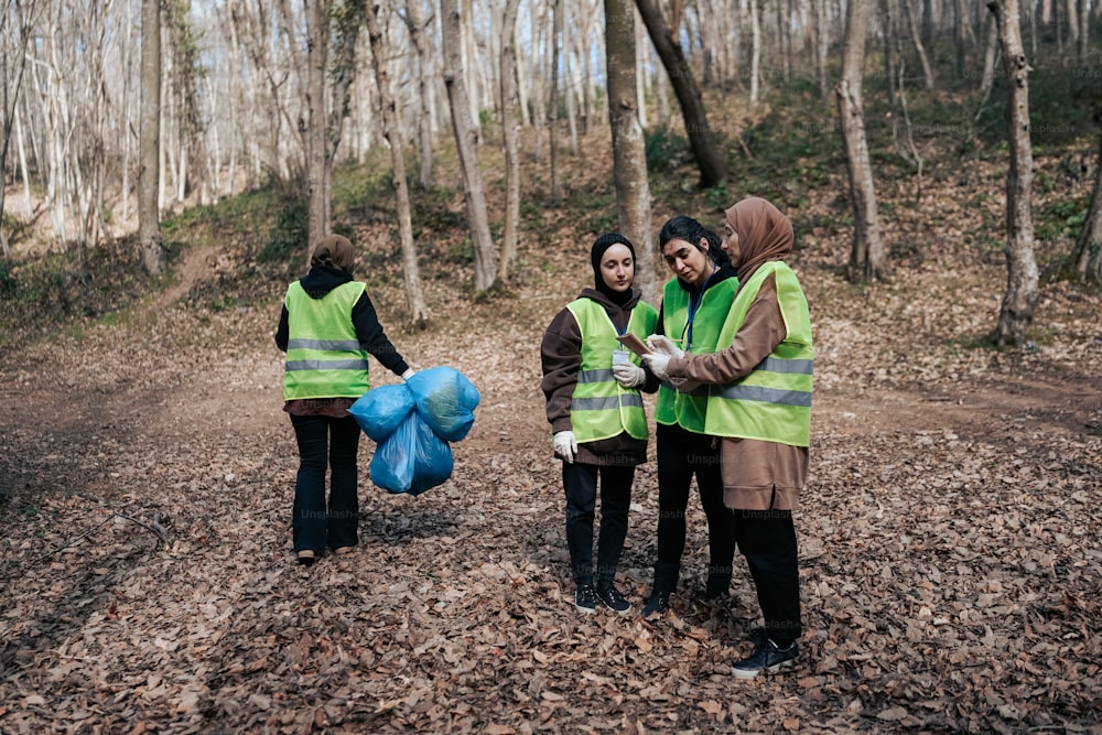 a group of people standing around each other in the woods