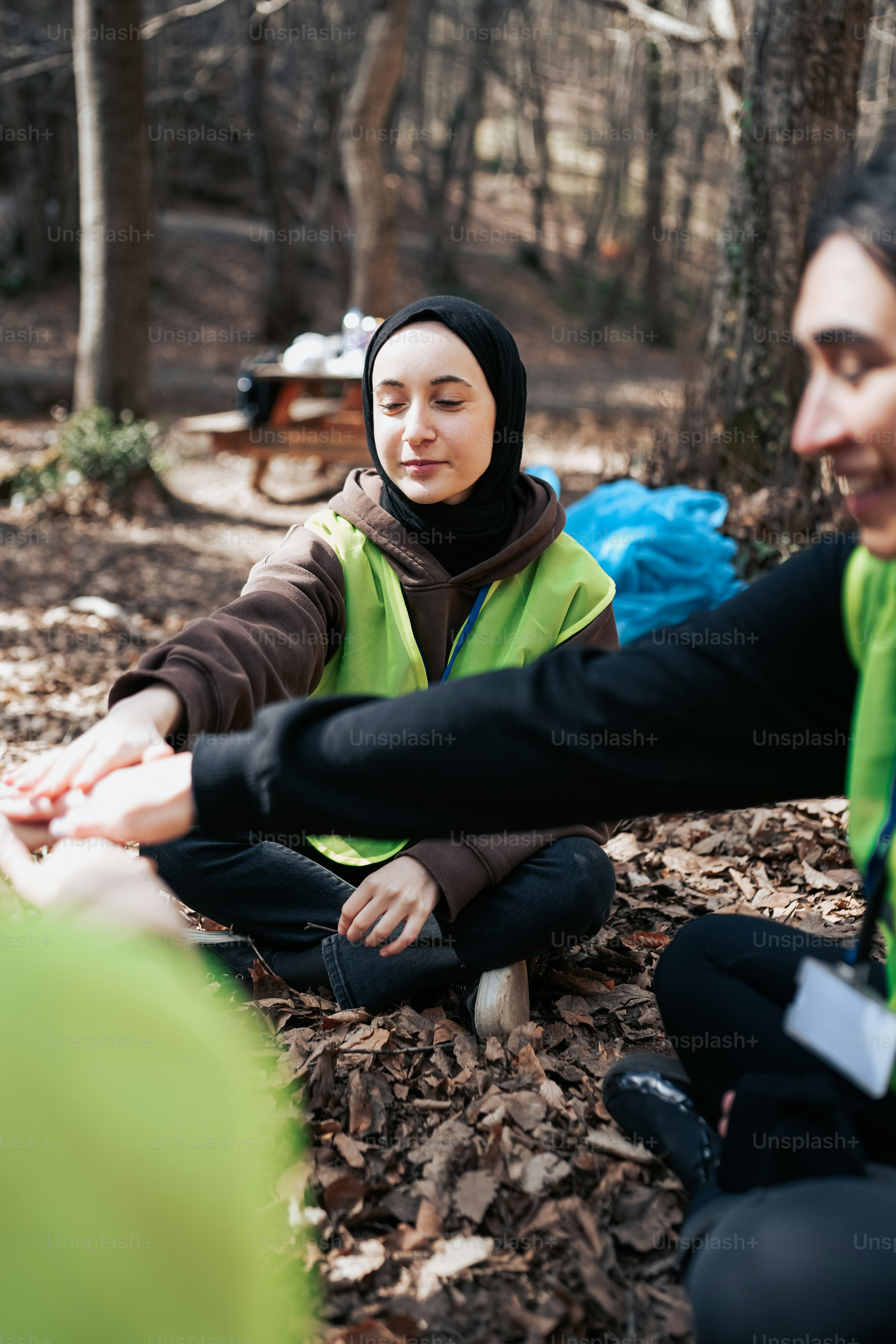 Zwei Frauen sitzen auf dem Boden im Wald