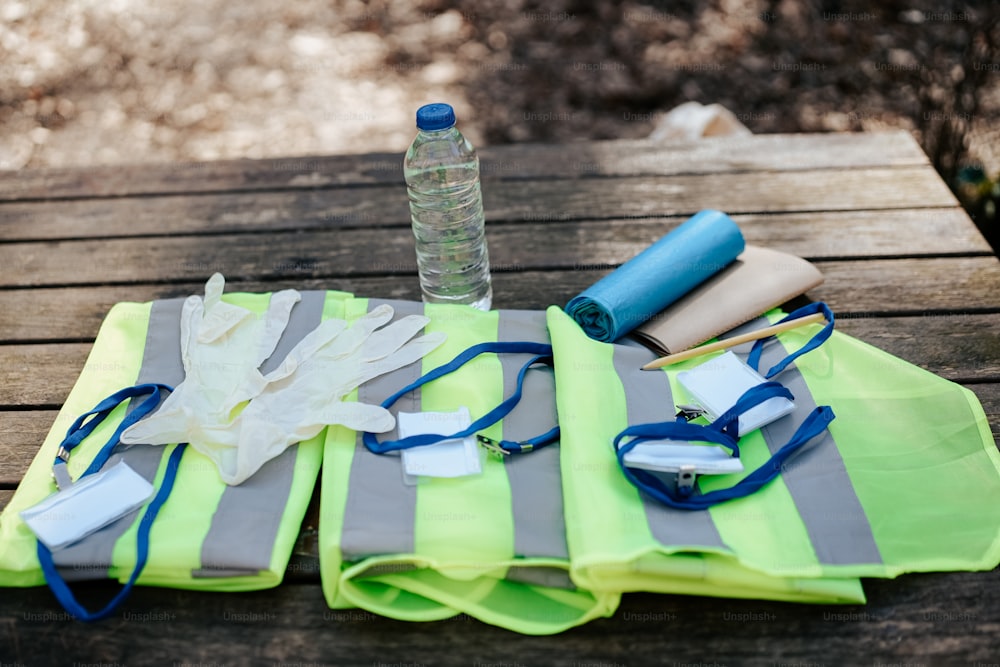a picnic table with a bottle of water, gloves, and other items