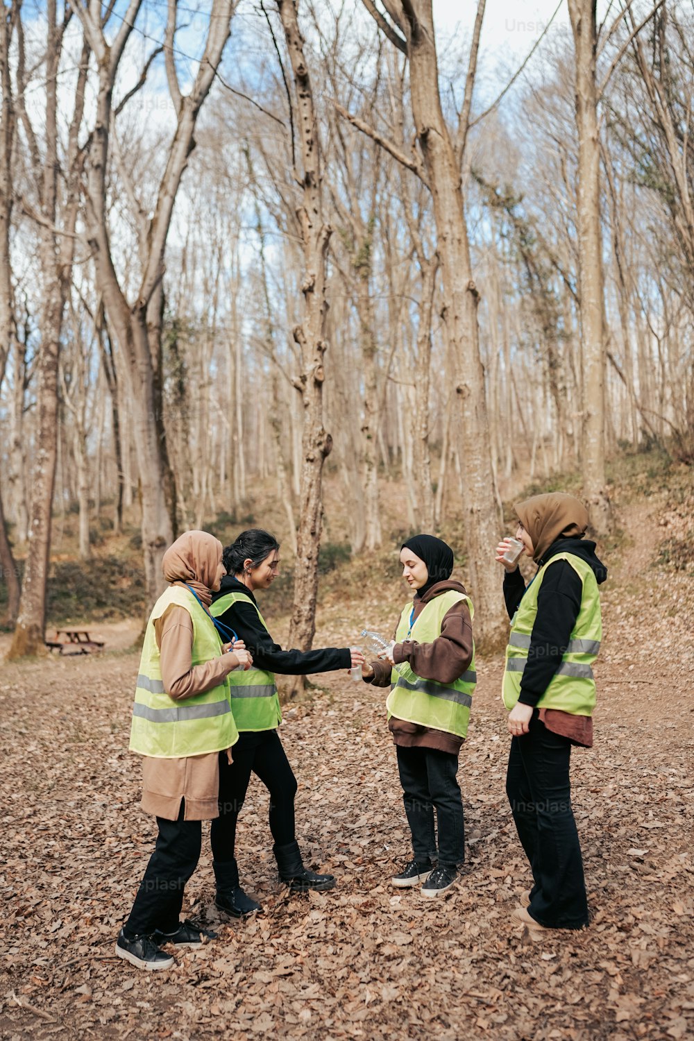 a group of people standing around each other in the woods
