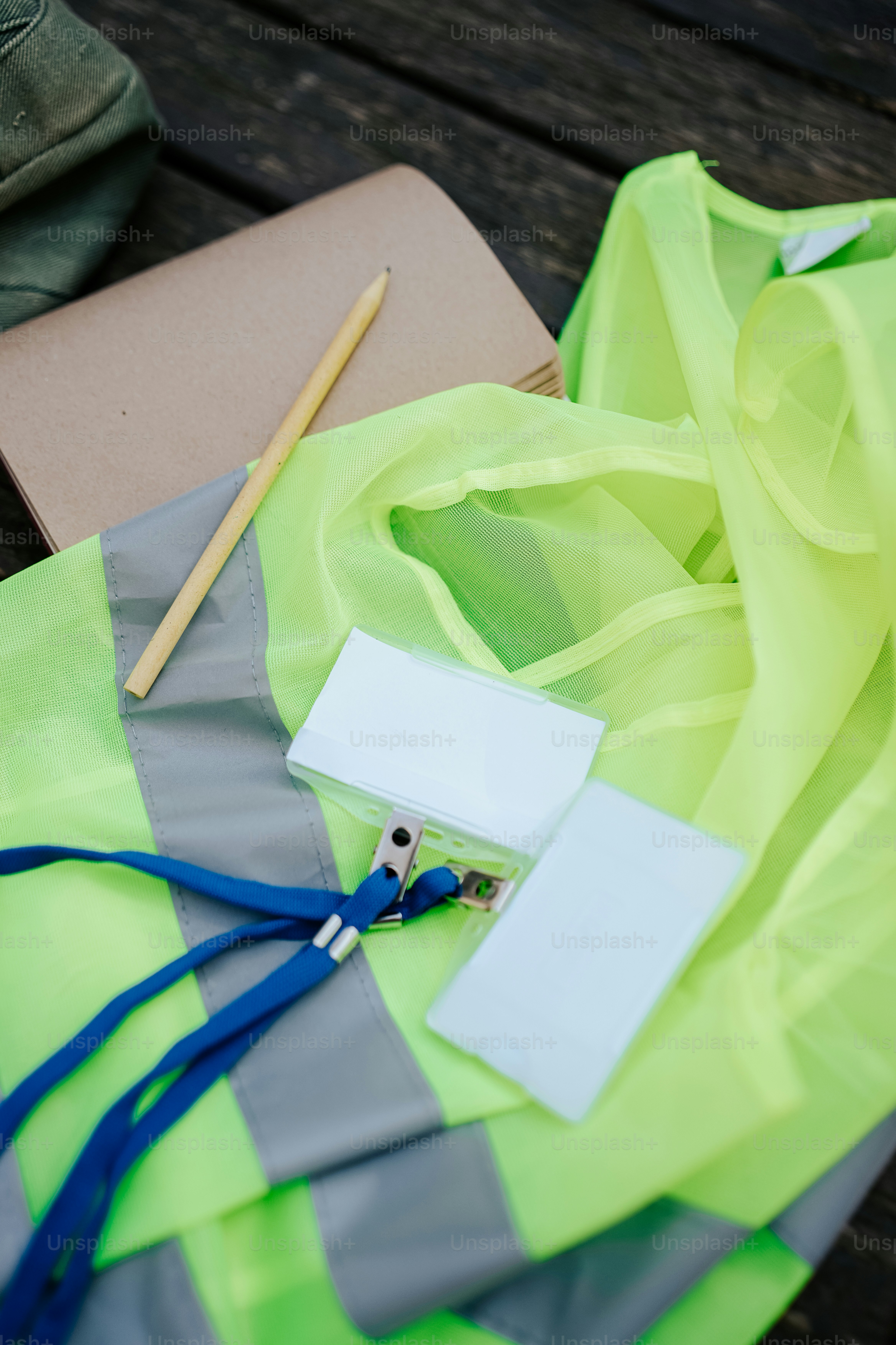 ein Paar Schuhe und eine gelbe Weste auf einem Holztisch