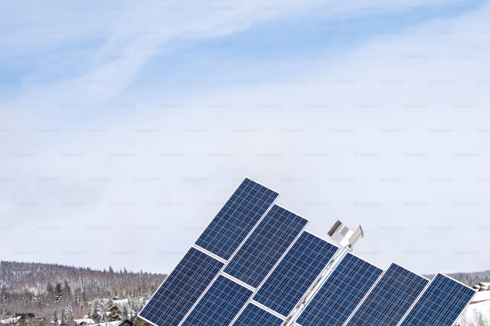 a group of solar panels on top of a snow covered hill