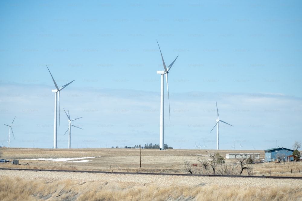 a group of windmills in a field of dry grass