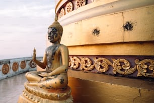 a statue of a buddha sitting on a ledge