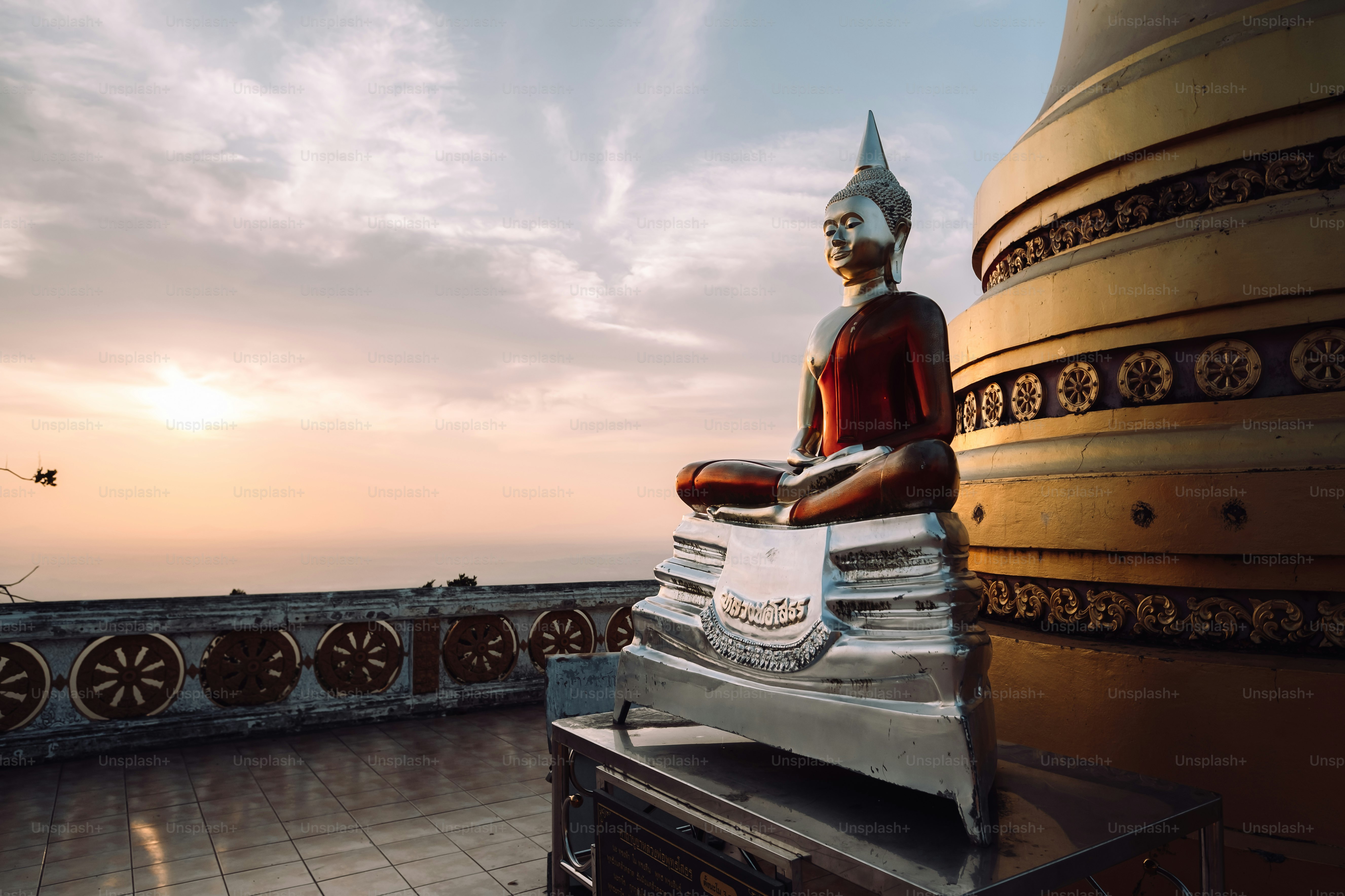 a buddha statue sitting on top of a roof