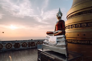 a buddha statue sitting on top of a roof