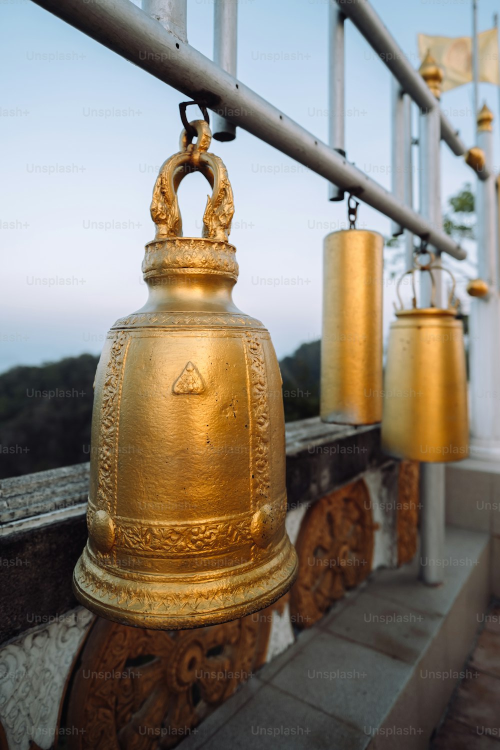 a golden bell is hanging on a railing
