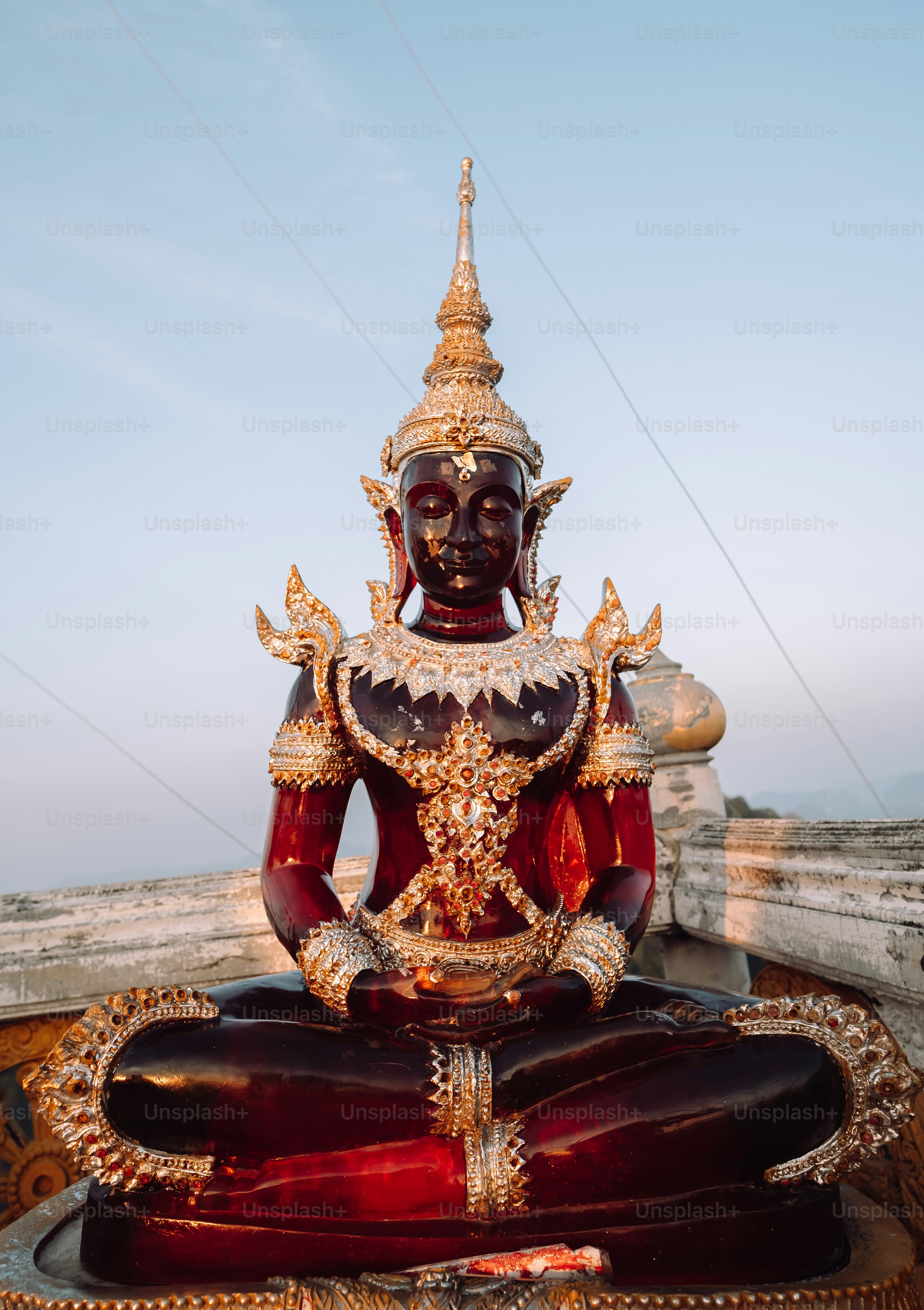 a statue of a person sitting on top of a wooden bench