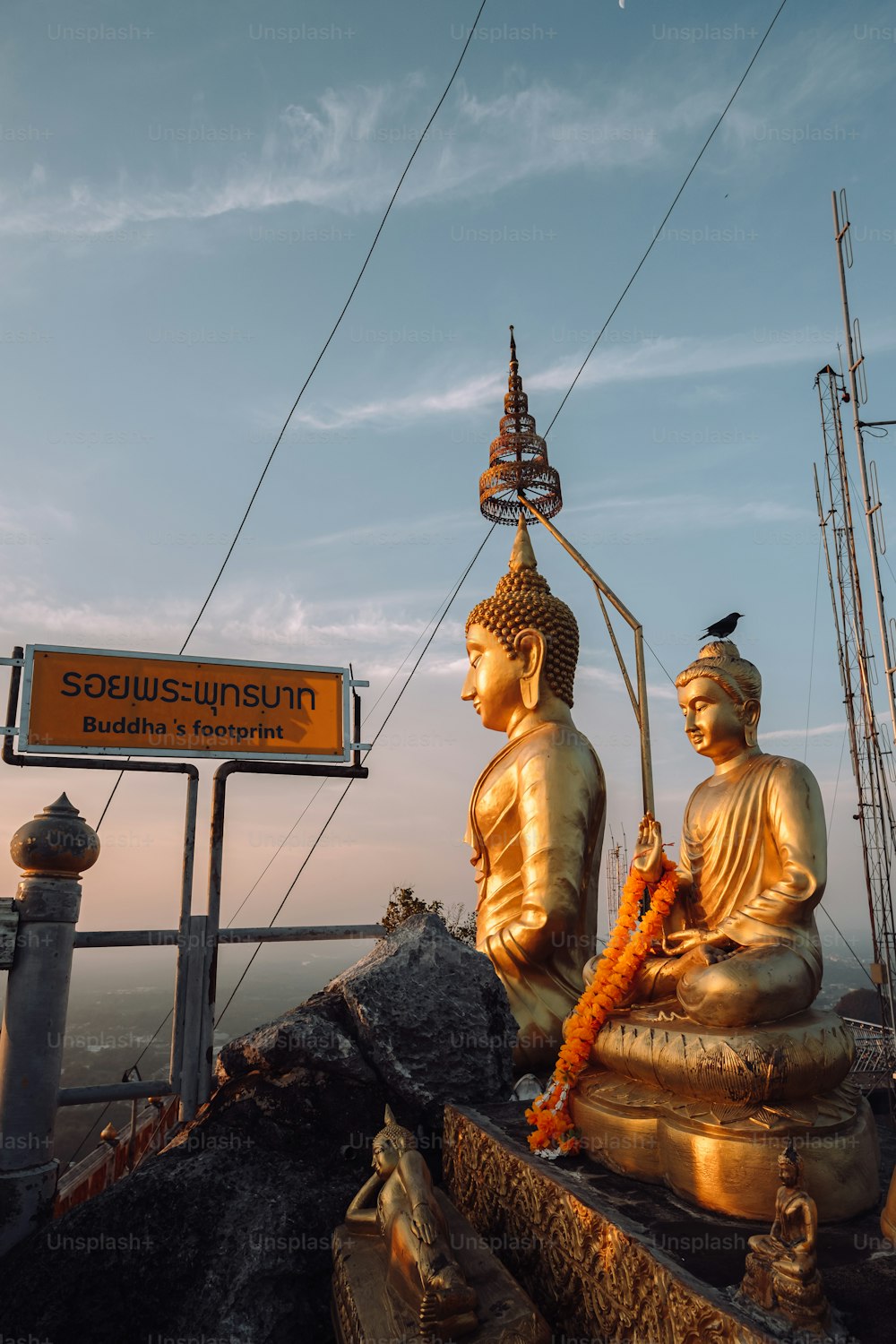 a couple of buddha statues sitting on top of a hill