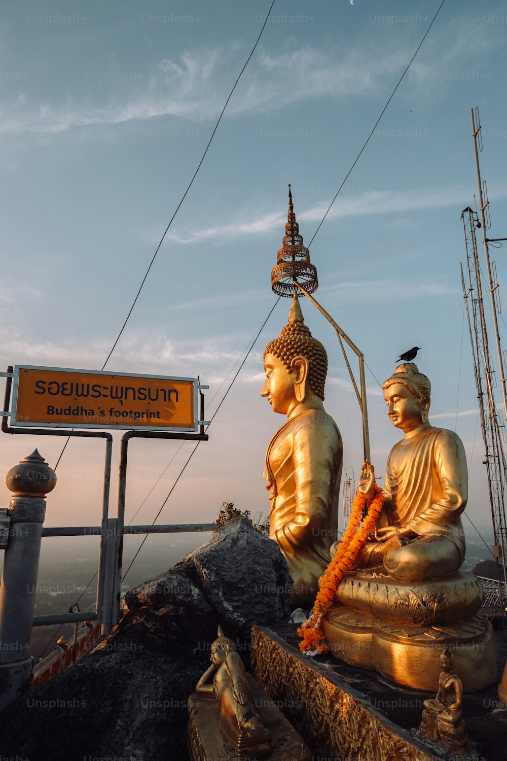um par de estátuas de Buda sentadas no topo de uma colina
