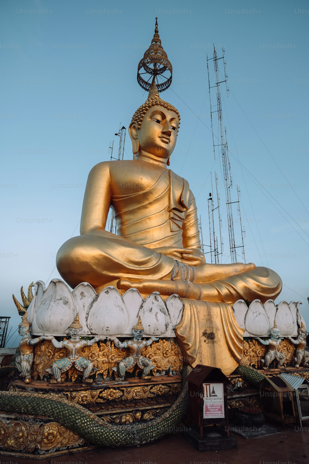 uma grande estátua dourada de buddha sentada em cima de uma mesa