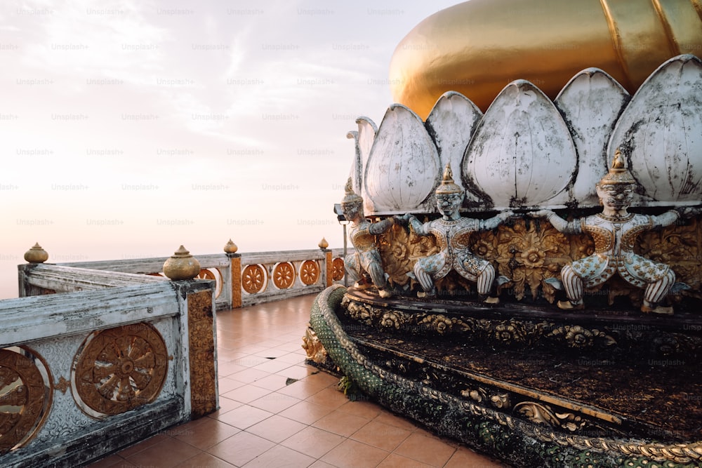 a large golden and white building with a clock on it's side