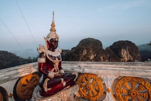 a statue sitting on top of a wooden structure