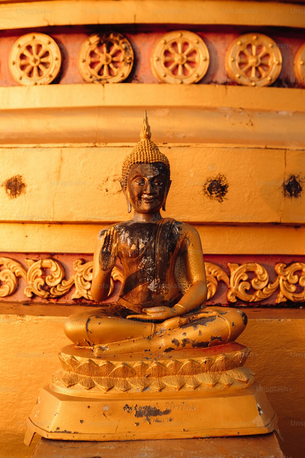 eine Buddha-Statue, die auf einem Holztisch sitzt