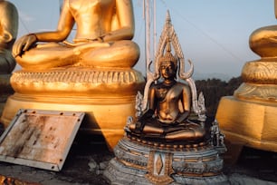 a golden buddha statue sitting on top of a pile of gold statues