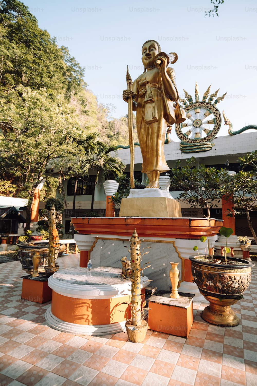 a statue of a man holding a staff in front of a building