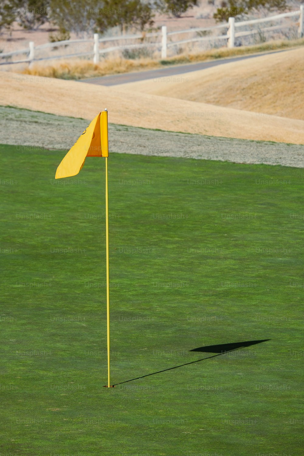 a yellow flag on a green golf course