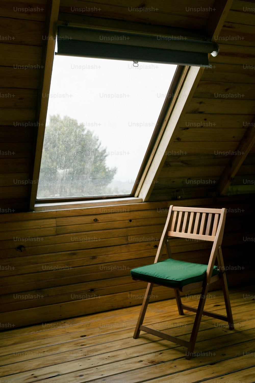 una sedia di legno seduta in una stanza sotto una finestra