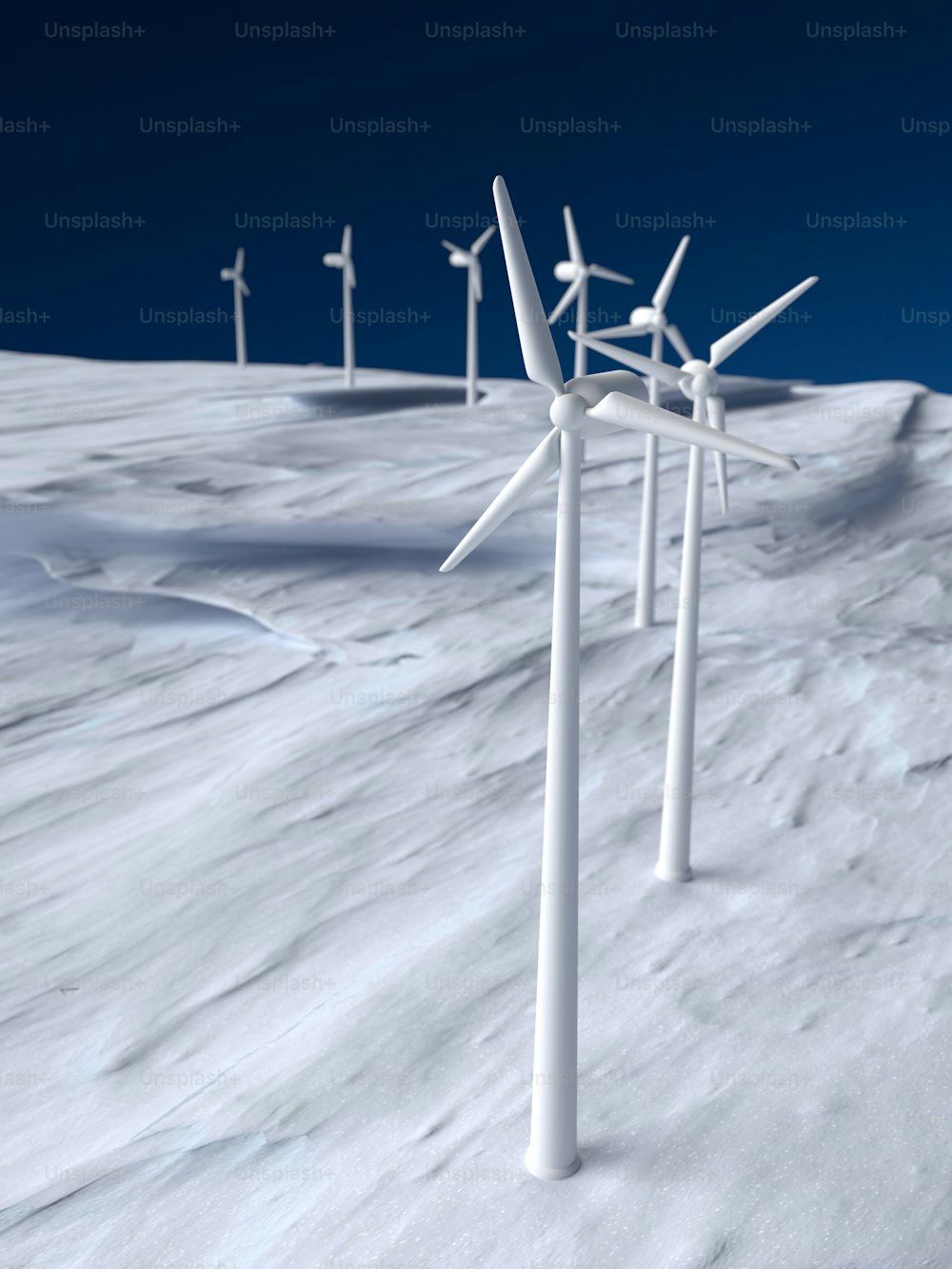 Un grupo de turbinas eólicas de pie en la cima de una pendiente cubierta de nieve