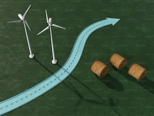 a road going through a wind farm with hay bales next to it