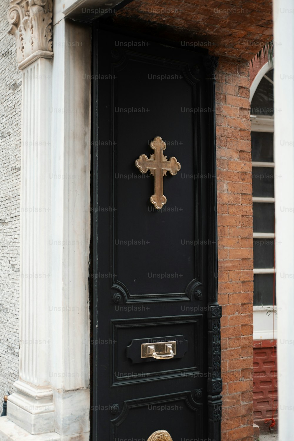 una puerta negra con una cruz