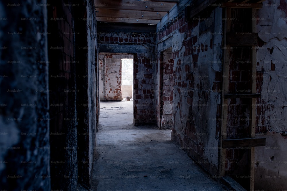 an empty room with a brick wall and a ladder