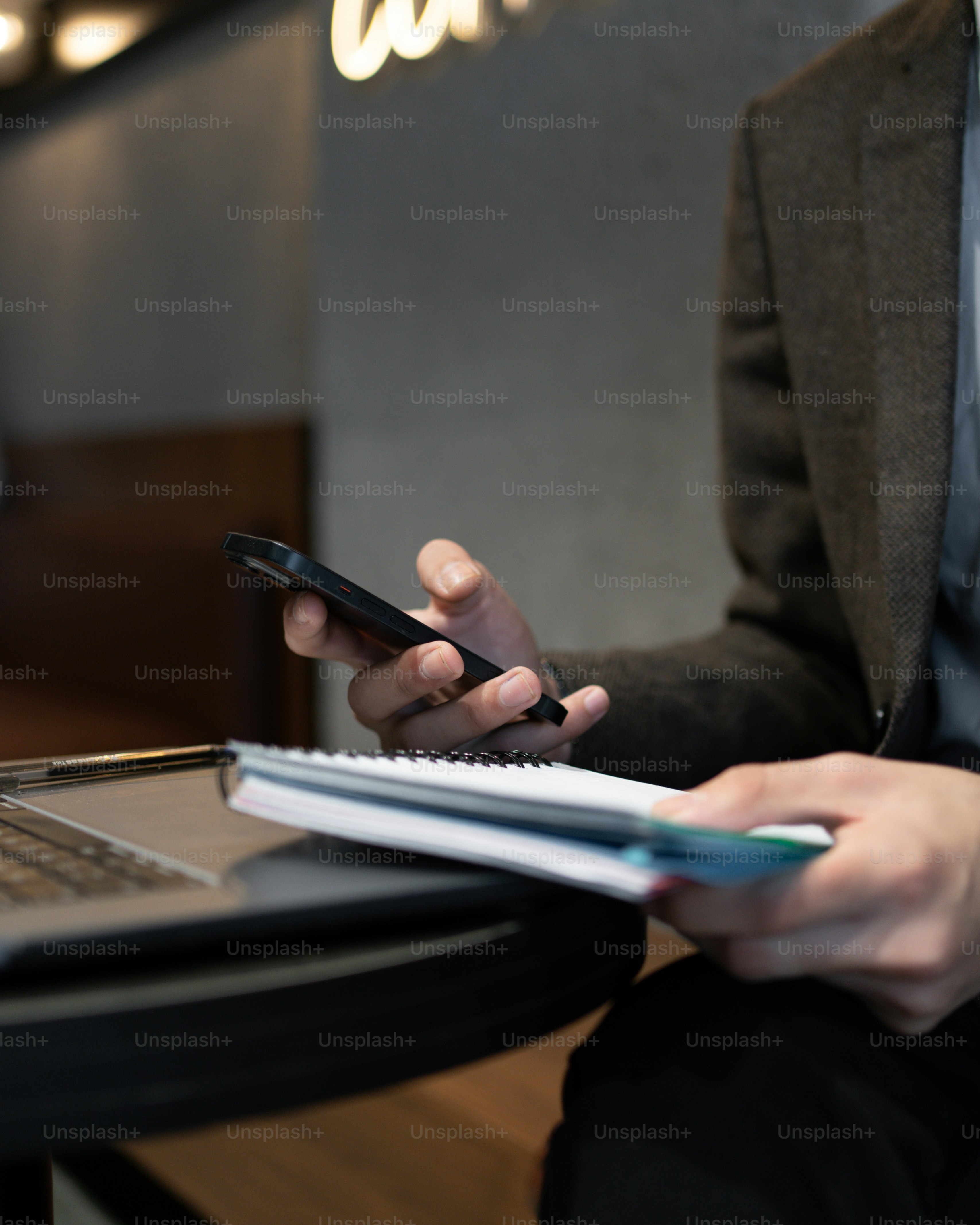 a person sitting at a table using a cell phone