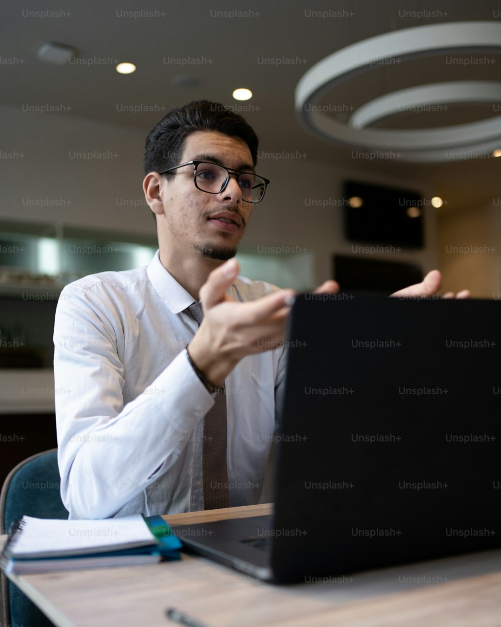a man sitting at a table with a laptop computer