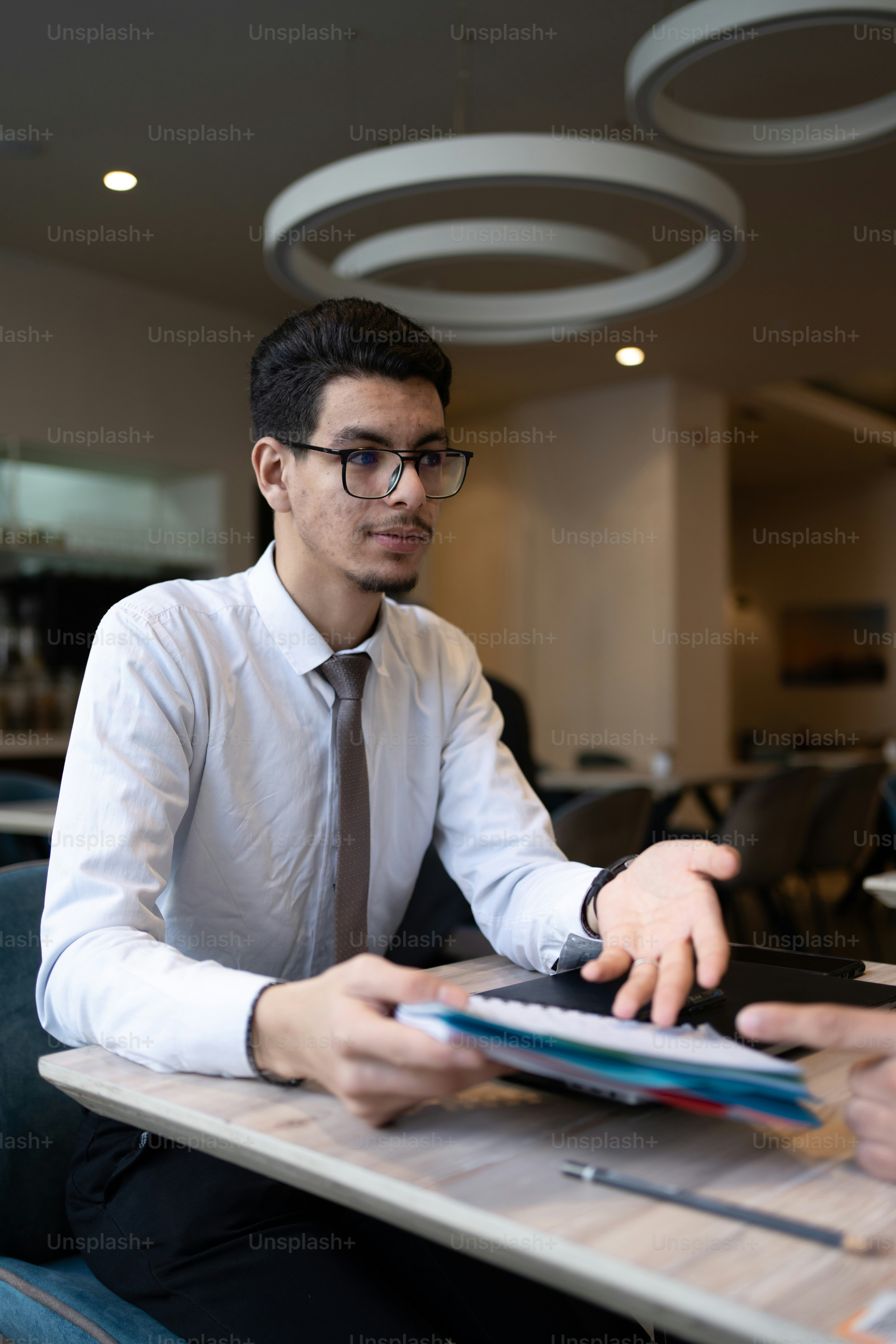 a man sitting at a table with a tablet