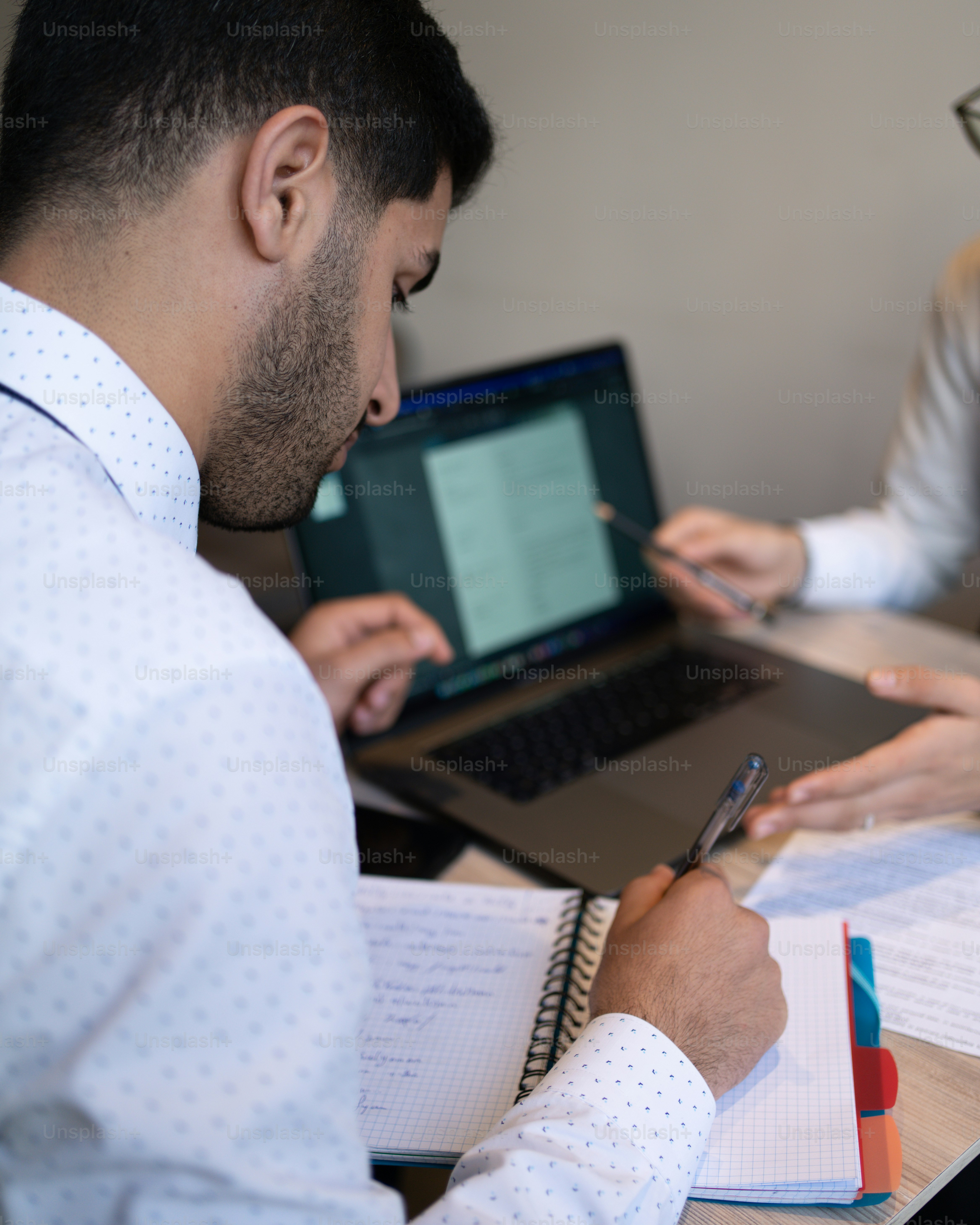 a man sitting at a desk with a laptop computer