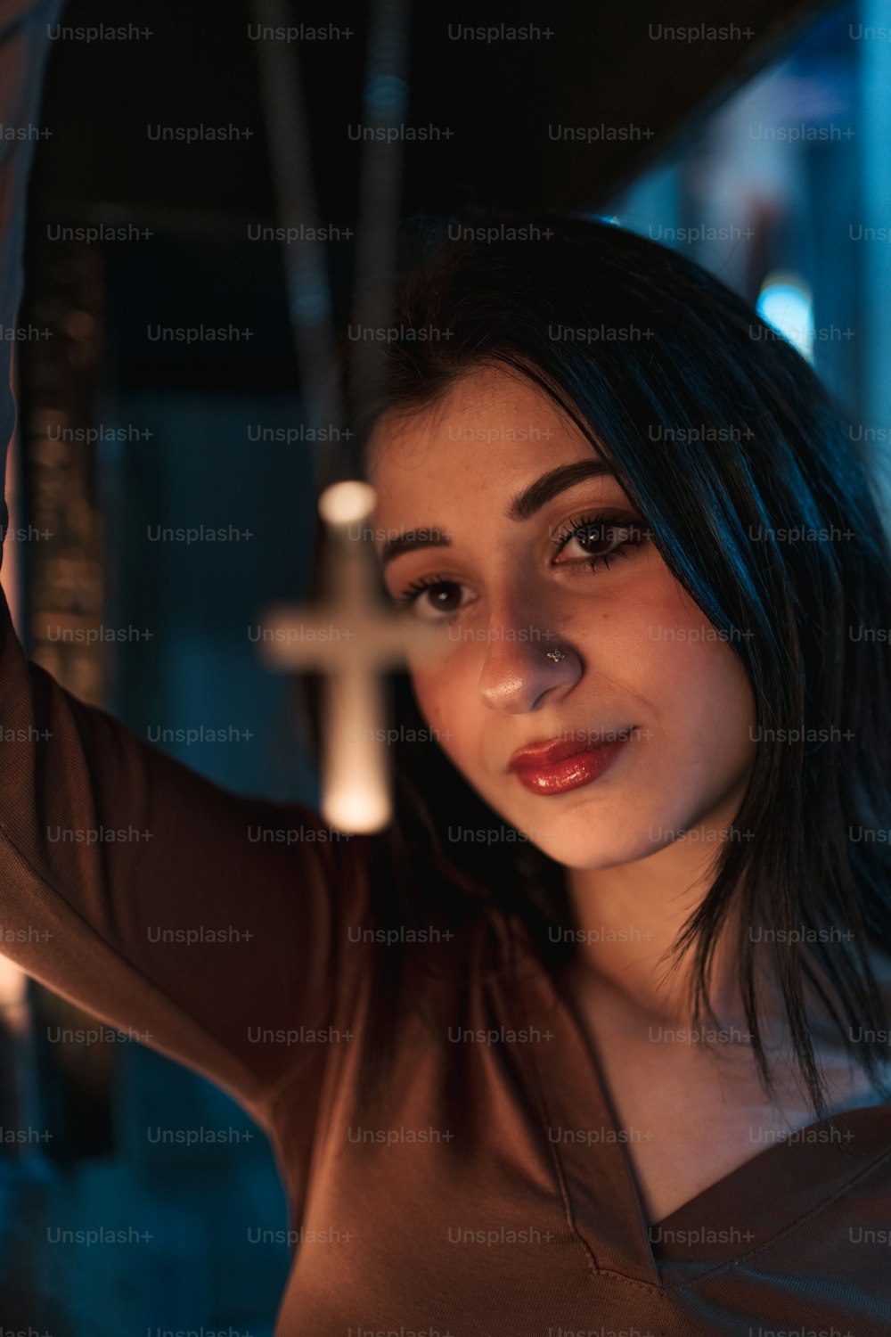 Eine Frau posiert für ein Bild mit einem Kreuz im Hintergrund