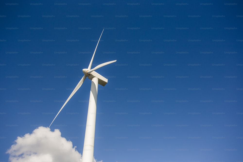 a wind turbine in the middle of a blue sky