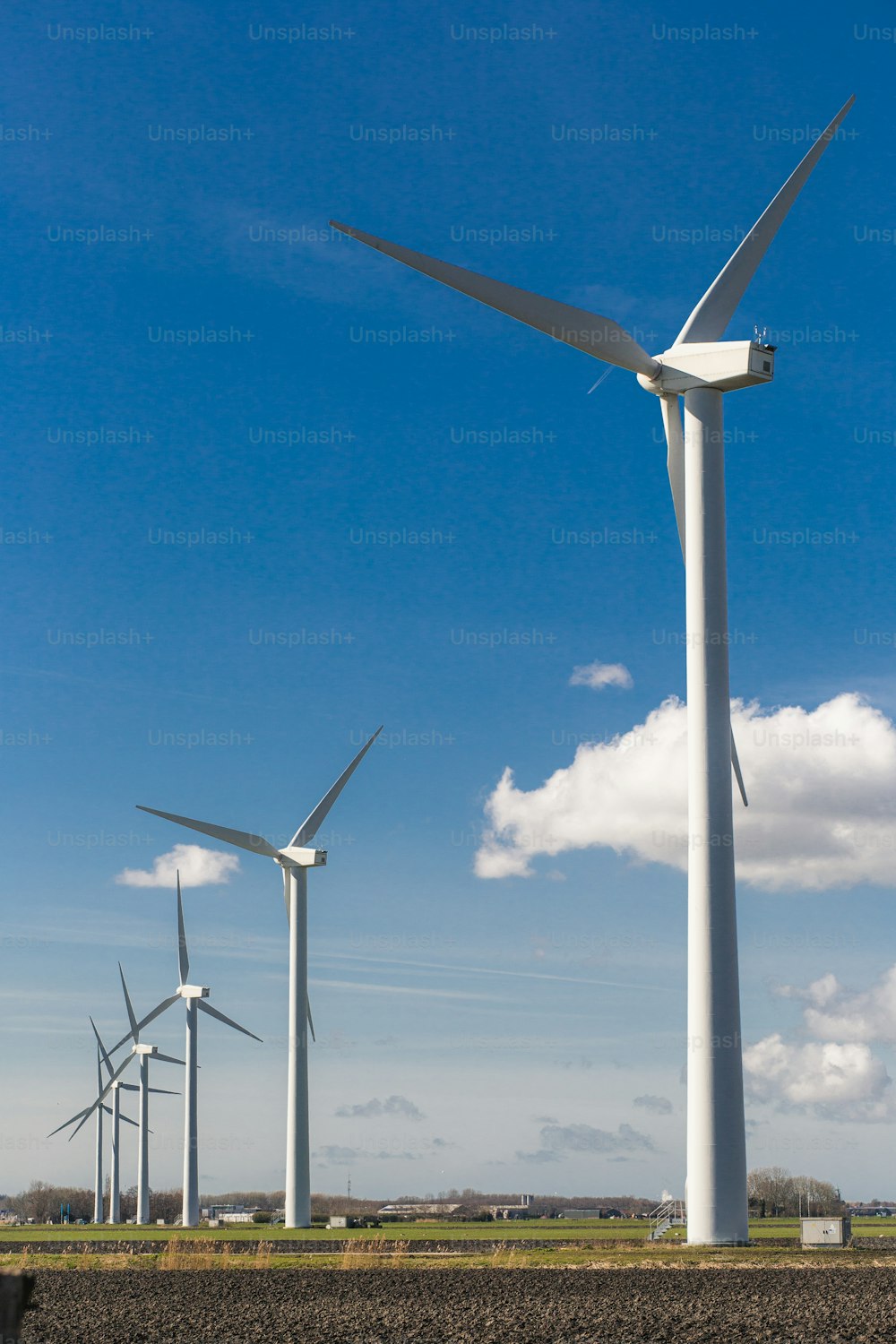 Una fila de turbinas eólicas en un campo