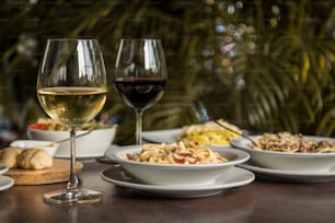 uma mesa coberta com pratos de comida e copos de vinho