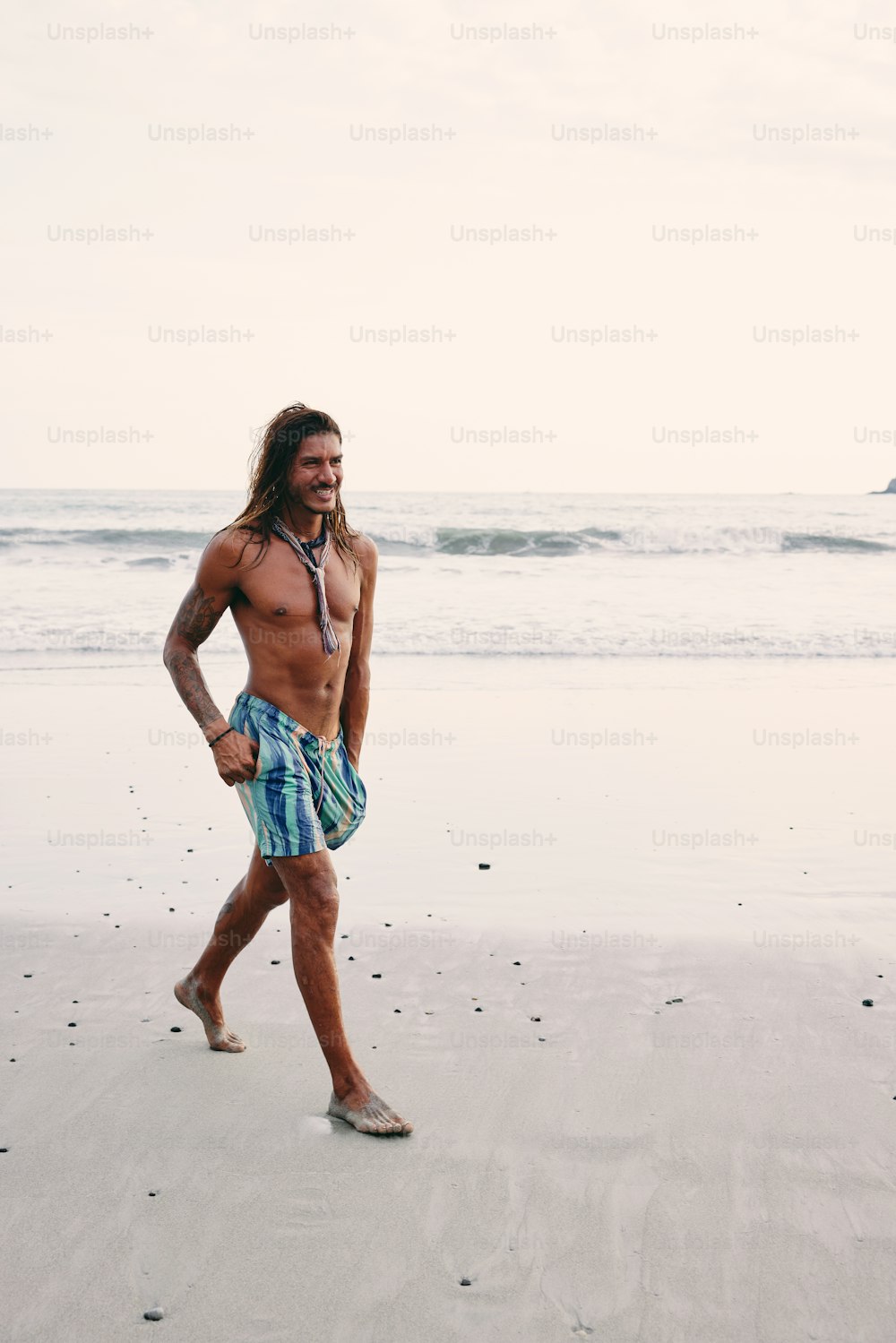 a man walking on a beach next to the ocean