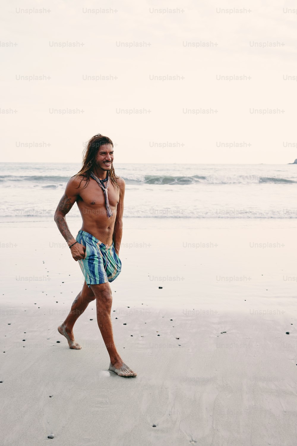 Ein Mann geht an einem Strand am Meer spazieren