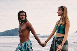 Un hombre y una mujer tomados de la mano en la playa