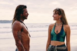 a man and a woman standing next to each other on a beach