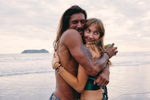 a man and a woman hugging on the beach