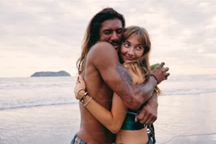 Un homme et une femme s’étreignent sur la plage