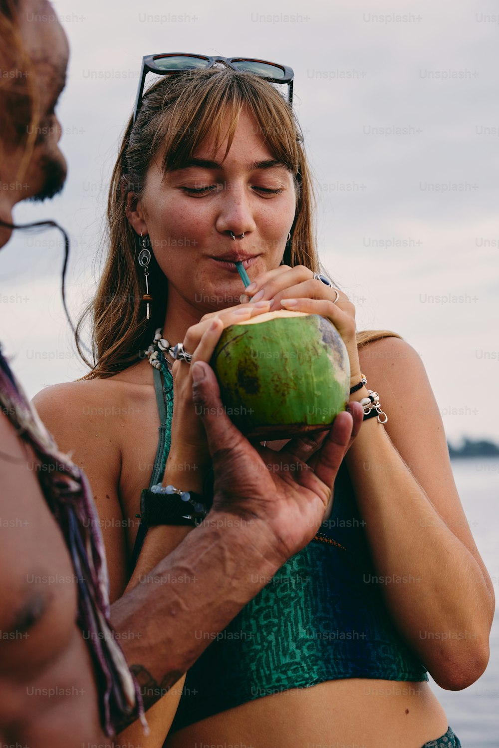 a woman in a bikini drinking from a coconut