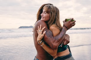a woman hugging a man on the beach