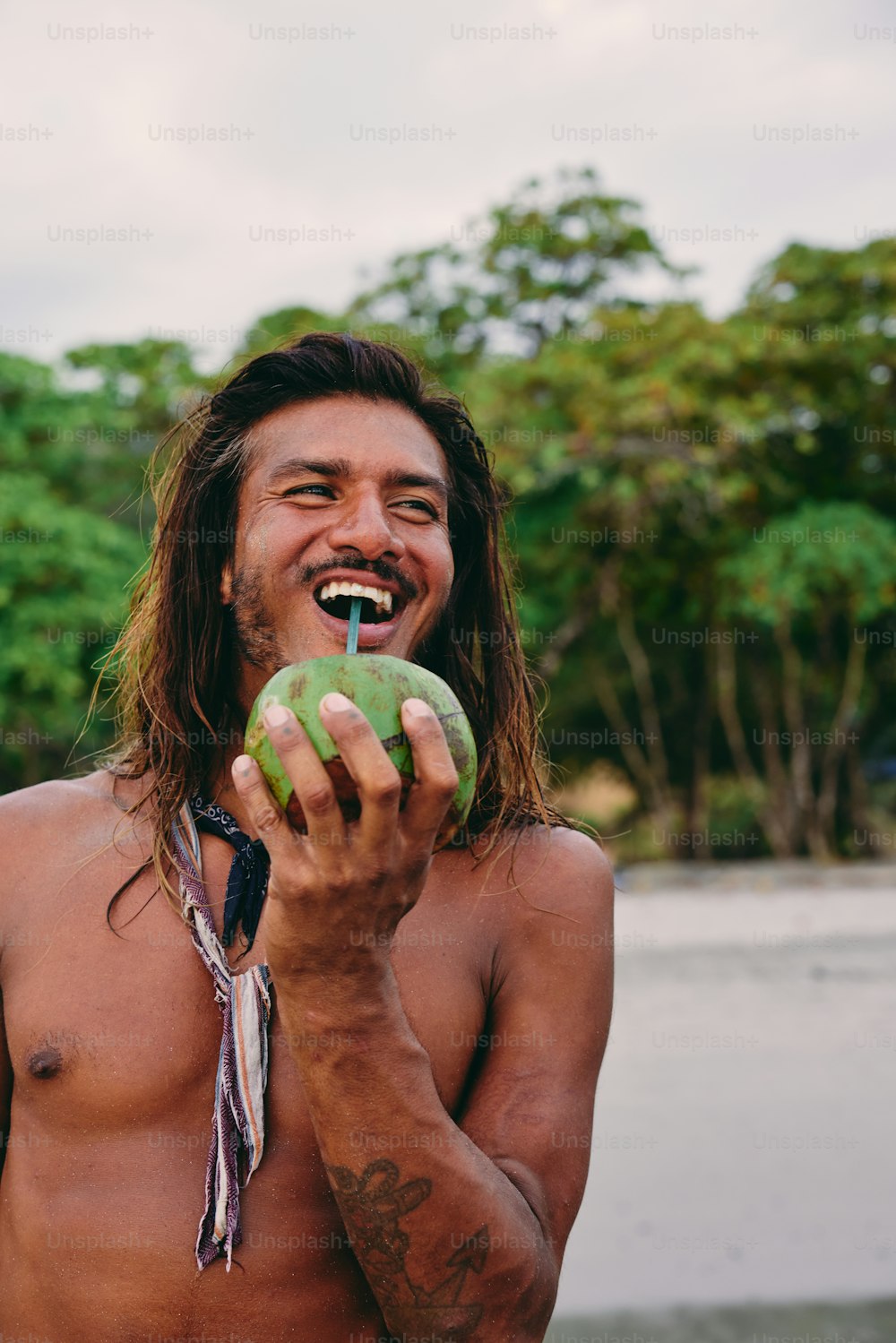 a man with long hair holding a green apple
