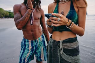 a man and a woman standing next to each other on a beach